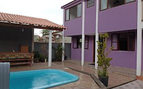 Casa roxa com piscina em condomínio